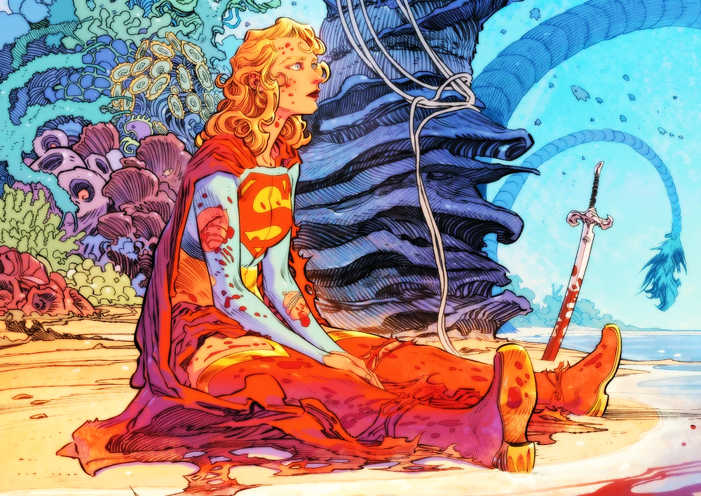 supergirl sits on a beach with a sword embedded upright in the sand next to her. she is covered in blood and looking pensively into the distance.